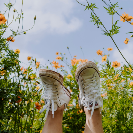voeten in de lucht gestoken tussen de bloemen